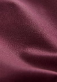 Țesătură bordeaux cu o textură netedă și un ușor luciu, având un model de țesătură uniform. Drapare moale cu pliuri subtile.