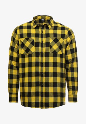 Kollane ja must ruuduline flanellsärk, millel on pikad varrukad, nööbid ette ja kaks rinnah Kuhja. Pehme tekstuur ja traditsiooniline ruuduline muster.