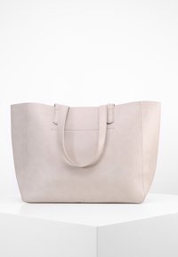 Beżowa skórzana torba na ramię z dwoma uchwytami, prostokątny kształt, gładka faktura, minimalne przeszycia i subtelny relief na przodzie.