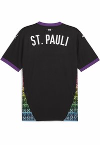Camisa deportiva negra con ribete púrpura en el cuello. La parte trasera presenta "ST. PAULI" en blanco y un patrón geométrico colorido a lo largo de los lados.