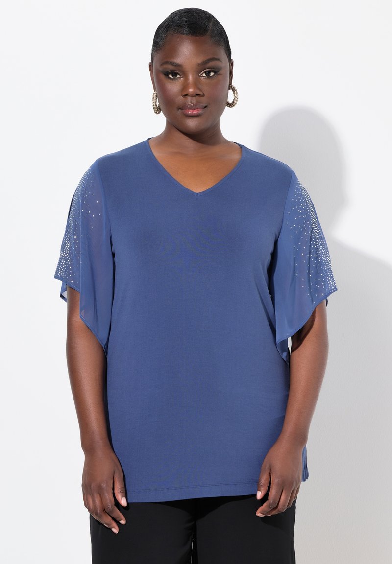 Top blu V con scollatura a V e maniche corte fluide, con decorazioni sulle maniche. Realizzato in tessuto morbido, ha una vestibilità ampia e spacchetti laterali.