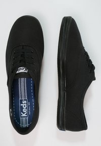 Musta kangastennarit pyöreillä kärjillä, viidellä nauhalenkillä, mustilla nauhoilla ja kontrastisinisellä pohjallisella. Kuminen pohja, jossa kuvioitu pito.