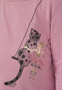 Camicia rosa con un grafico di un gatto con motivi a cuore e una ballerina in tutù di tulle, contornata di nero su un tessuto liscio.