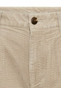 Beige corduroy pants featuring a button closure, textured vertical ridges, and traditional pockets along the waistband.