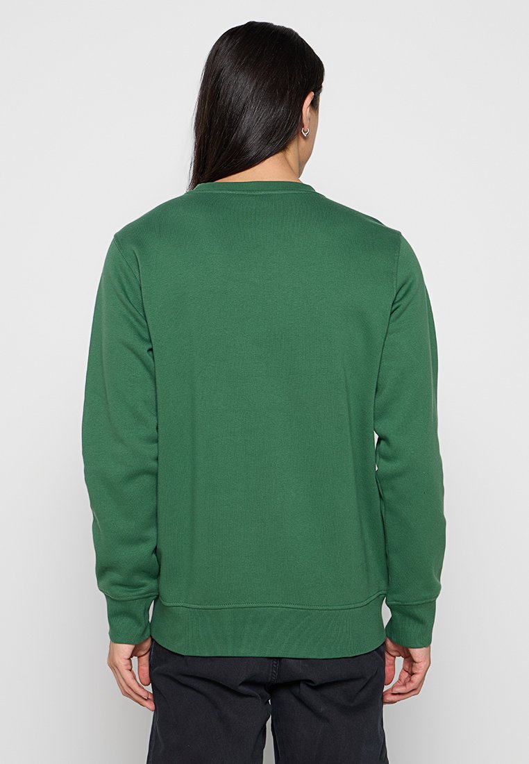 Sudadera verde de manga larga, cuello redondo, con puños y dobladillo de canalé, hecha de una mezcla de algodón texturizada.