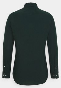 Ciemnozielona, długa koszula z długim rękawem z zapiętymi mankietami, widoczna z tyłu, na jednolitym białym tle.