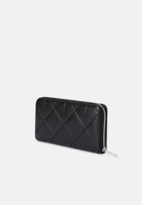 Prešívaná čierna kožená peňaženka so strieborným zipsom, obdĺžnikového tvaru, s diamantovým vzorom a hladkým povrchom.