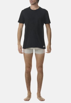 Schwarzes T-Shirt mit kurzen Ärmeln, Rundhalsausschnitt, weiche Textur; graue Boxershorts darunter; beide Kleidungsstücke sind lässig gestylt.