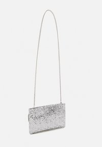 Pochette argentée métallique avec une finition en sequins texturés, forme rectangulaire, et une longue bandoulière en chaîne métallique.