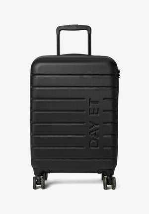 Valise noire à roulettes avec une surface texturée à nervures, logo en relief, poignée rétractable et quatre roues pour la mobilité.