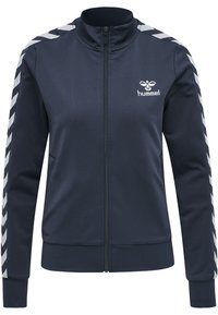 Marinblå zip-up jacka tillverkad av slät tyg, med vita chevronränder längs axlarna och en logotyp på bröstet.
