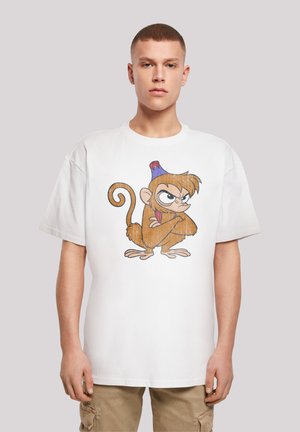 White cotton t-shirt featuring a cartoon monkey design with brown fur, a blue and red party hat, and an exaggerated frown. Casual fit.