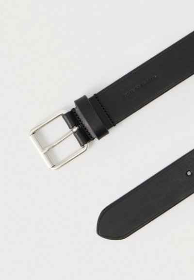 Μαύρη δερμάτινη ζώνη με ασημί μεταλλική αγκράφα. Διαθέτει λεία υφή, ραμμένη λεπτομέρεια και πολλαπλές τρύπες ρύθμισης κατά μήκος του ιμάντα.