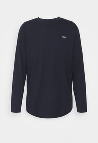 Langärmliges navy-blaues Hemd aus weichem Stoff, mit Rundhalsausschnitt und kleinem weißen Logo im oberen Rückenbereich, glatte Textur.