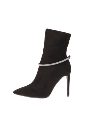 Stivale in suede nero fino alla caviglia con punta affusolata, tacco a spillo e catena metallica decorativa attorno alla caviglia. Texture liscia e design aderente.