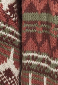 Pletená svetr fabric s alternativními vzory v tmavě červené, zelené a bílé, se zolními texturami a měkkým, chmýřovitým vzhledem.