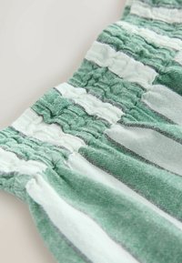 Audums ar zaļām un baltām horizontālām svītrām; izceļas ar savākta tekstūras efektu ar elastību stiepšanai; mīksts, viegls materiāls.