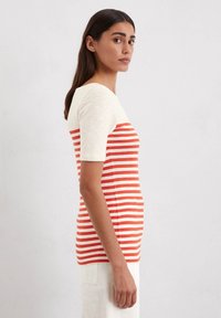 Gestreepte t-shirt met korte mouwen, een crèmekleurig bovenstuk en een oranje onderstuk met horizontale strepen. Gemaakt van een katoenmix.