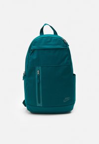 Teal Nike backpack with a rounded design, featuring a front zip pocket, side pocket, and logo accent. Made from durable fabric.