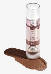 Langvarig foundation i en frostet flaske med pumpe, merket "IRL FILTER F15," med en myk matt finish og en mørkebrun fargeprøve.