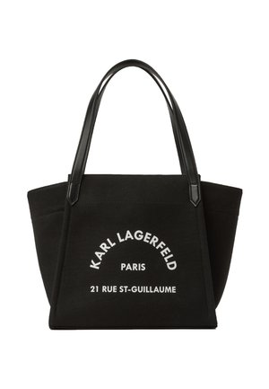 Czarna prostokątna torba typu tote z skórzanymi uchwytami, z białym napisem "KARL LAGERFELD PARIS 21 RUE ST-GUILLAUME" na przedzie.