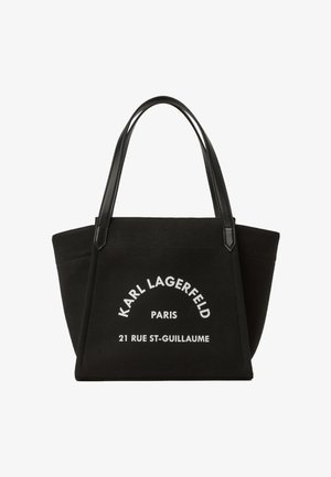 Sac fourre-tout rectangulaire noir avec poignées en cuir, comportant un texte blanc "KARL LAGERFELD PARIS 21 RUE ST-GUILLAUME" sur le devant.