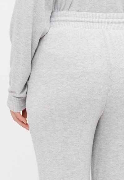 Pantalons de détente en tricot gris avec une taille côtelée et des poches latérales, présentant un tissu doux et texturé pour un confort optimal.