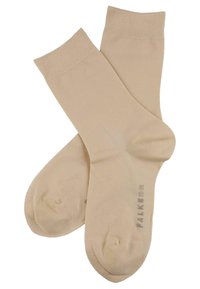 Beżowe skarpetki wykonane z gładkiego, elastycznego materiału z prążkowanym mankietem i wzmocnionym palcem. Zawierają subtelną naszywkę z logo na podeszwie.