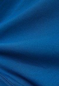 Tejido azul con una textura suave, que presenta un delicado patrón estriado. Material suave y ligero con un color uniforme en toda su extensión.