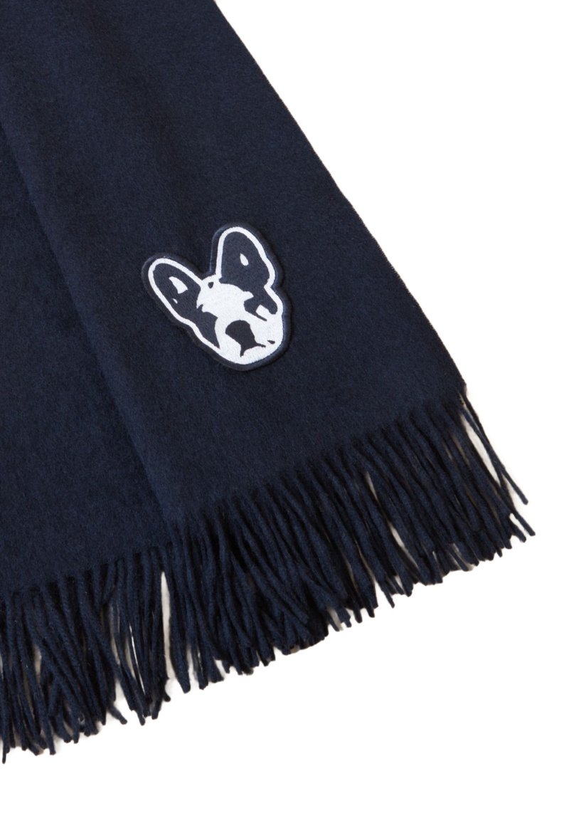 Écharpe bleu marine foncé avec des extrémités à franges et un patch brodé représentant un visage de bulldog français noir et blanc près du bord.