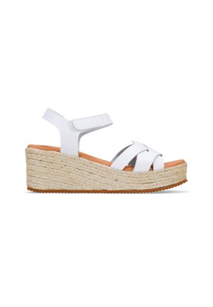 Sandalias de plataforma blancas que presentan un diseño de tiras cruzadas, una correa ajustable en el tobillo y una suela de yute trenzado con un acabado texturizado.