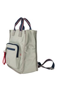 Mochila de nailon gris claro con asas a rayas en azul marino y rojo, cuenta con un bolsillo delantero azul con cremallera y una correa de hombro desmontable.