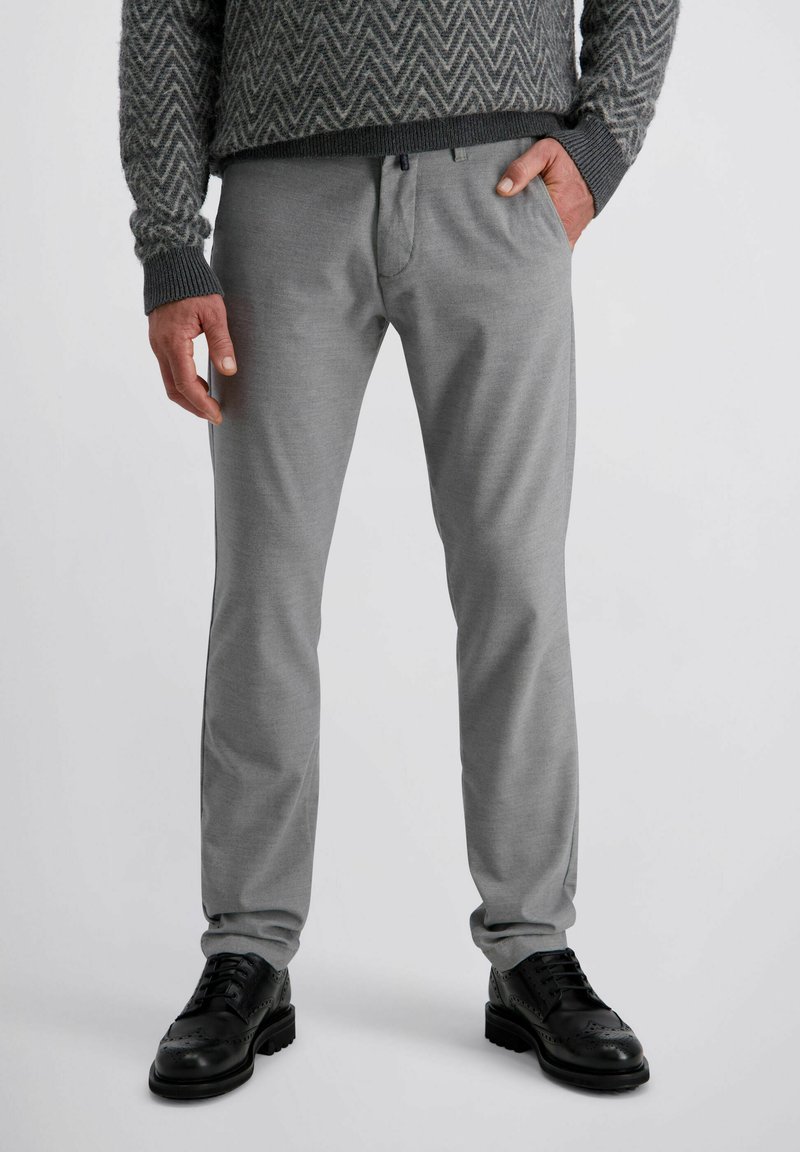 Graue Hosen mit einer glatten Textur, geradem Schnitt und subtilen Designdetails, kombiniert mit schwarzen Lederschuhen mit dekorativen Perforationen.