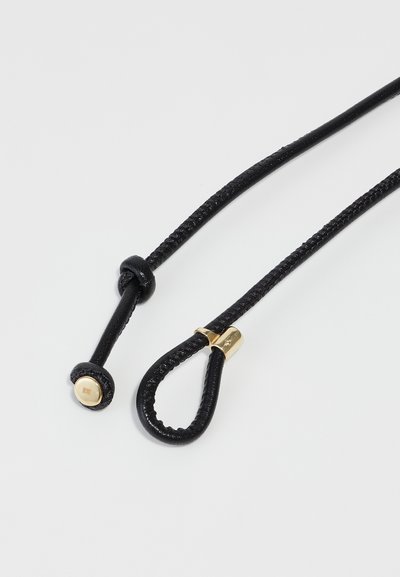 Black braided cord features a gold hardware clasp and a round end with a metal detail. The design is functional and streamlined.