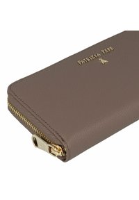 Cartera de cuero marrón con textura, herrajes dorados y detalle de cremallera. Presenta el logo de la marca grabado en el frente. De forma compacta y rectangular.