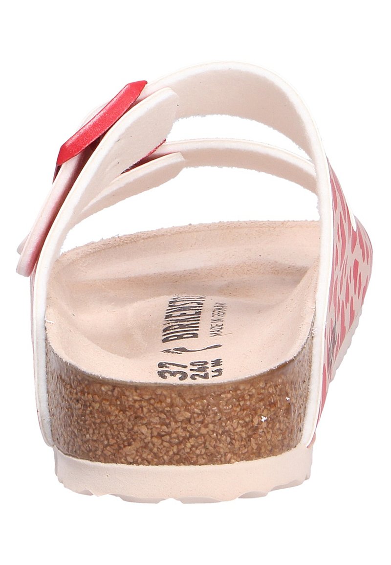 Sandalo a righe rosse e bianche con suola in sughero e cinturino regolabile. Presenta una superficie liscia simile alla pelle nella parte superiore.