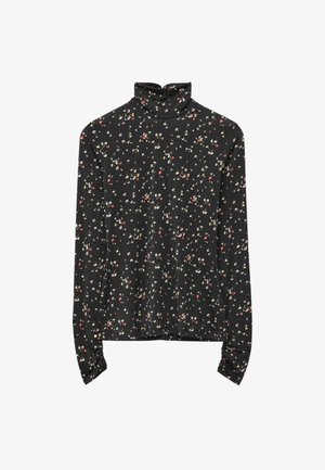 Long-sleeve turtleneck top in black fabric with a floral pattern in red, white, and green. Soft texture with fitted design and cuffed sleeves.