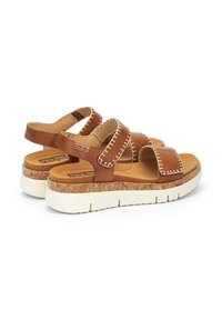 Sandalias de cuero marrón con suela de corcho, que cuentan con dos correas ajustables, detalles de costura blanca y una plantilla acolchada para mayor comodidad.