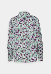 Chemise à manches longues avec un motif floral dense en violet, bleu sarcelle et vert sur fond blanc, vue de dos.