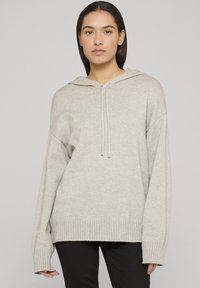 Felpa con cappuccio grigio chiaro con orlo e polsini a coste, caratterizzata da una vestibilità rilassata e chiusura con coulisse. Tessuto morbido, maniche lunghe.