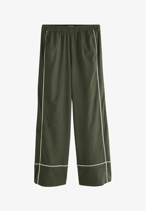 Olivegrüne Hosen mit weitem Bein, elastischem Bund, Seitentaschen und weißer Paspelierung entlang der Beine und nahe den Säumen.