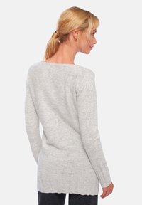 Pull gris clair à manches longues avec ourlet côtelé et tissu texturé, doté d'un large décolleté et d'un dos légèrement allongé.