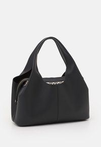 Czarna skórzana torba na ramię o gładkiej fakturze, zaokrąglonym kształcie oraz zamkniętej kieszeni na zamek. Wnętrze wykończone jest wzorzystą podszewką.