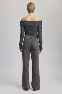 Mørk grå avlingstopp med avtagbare ermer og rynkede lange ermer, kombinert med høyt liv, brede, falmede svarte jeans med baklommer.