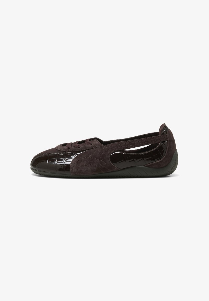 Chaussure plate marron foncé avec côtés découpés, textures en daim et cuir verni, et une semelle en caoutchouc flexible, vue de l'extérieur.