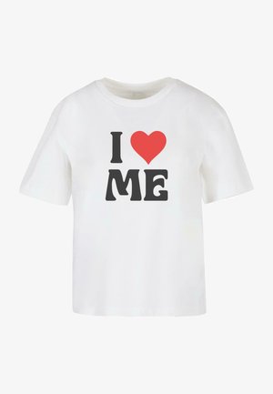 Camiseta de algodón blanca con manga corta, que presenta un texto en negro en negrita "I," un corazón rojo y "ME" en una fuente informal.