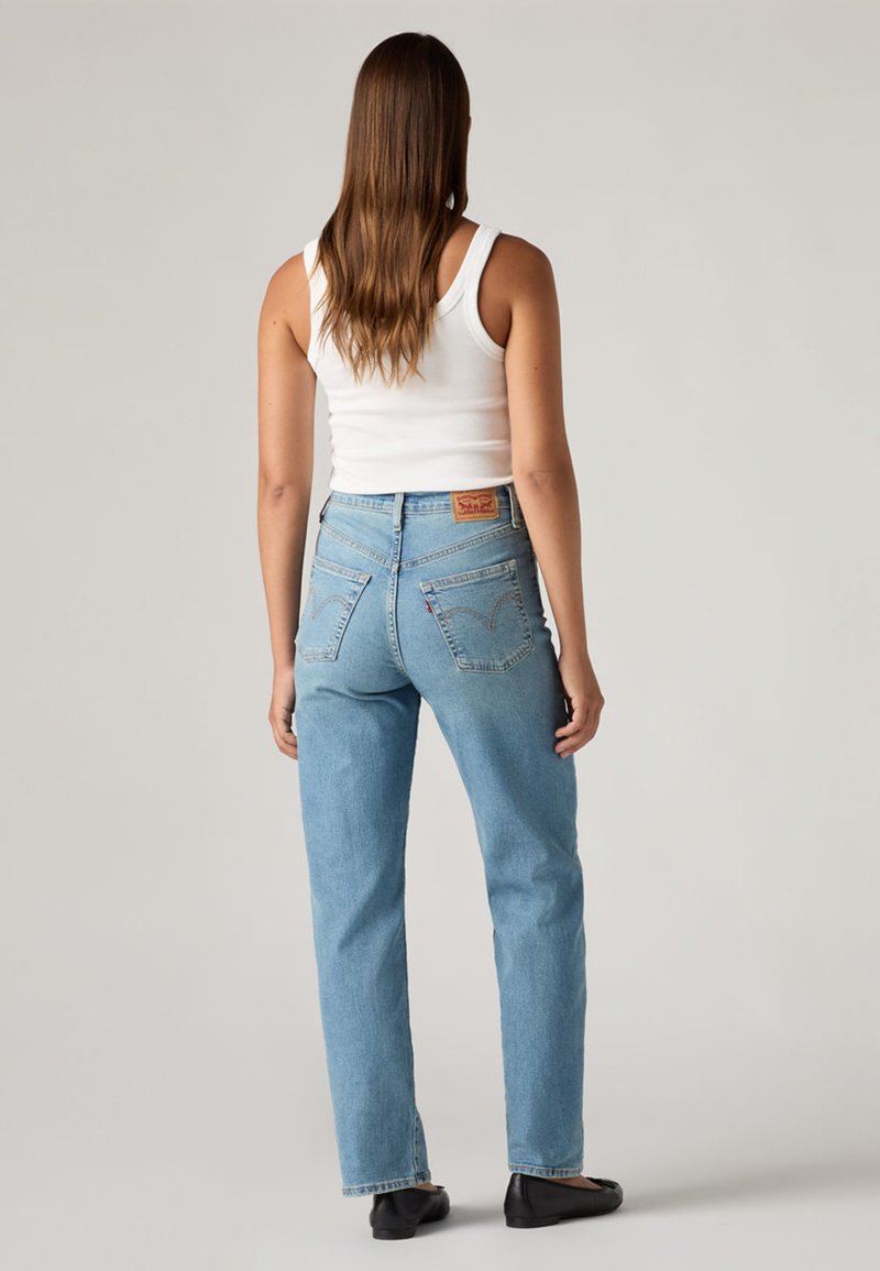 Jeans in denim azzurro chiaro con vestibilità dritta, vita alta e tasche posteriori. Presentano una patch in pelle con il marchio sulla cintura e cuciture minime.