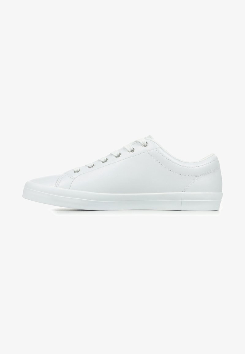 Sneaker blanche avec une tige en cuir lisse, bout arrondi, semelle en caoutchouc plate et six œillets en métal pour les lacets, présentant un design minimaliste.