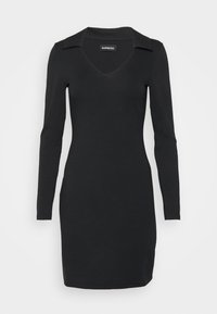 Robe noire ajustée à manches longues avec col en V et col, longueur au genou, présentée sur un fond clair uni.