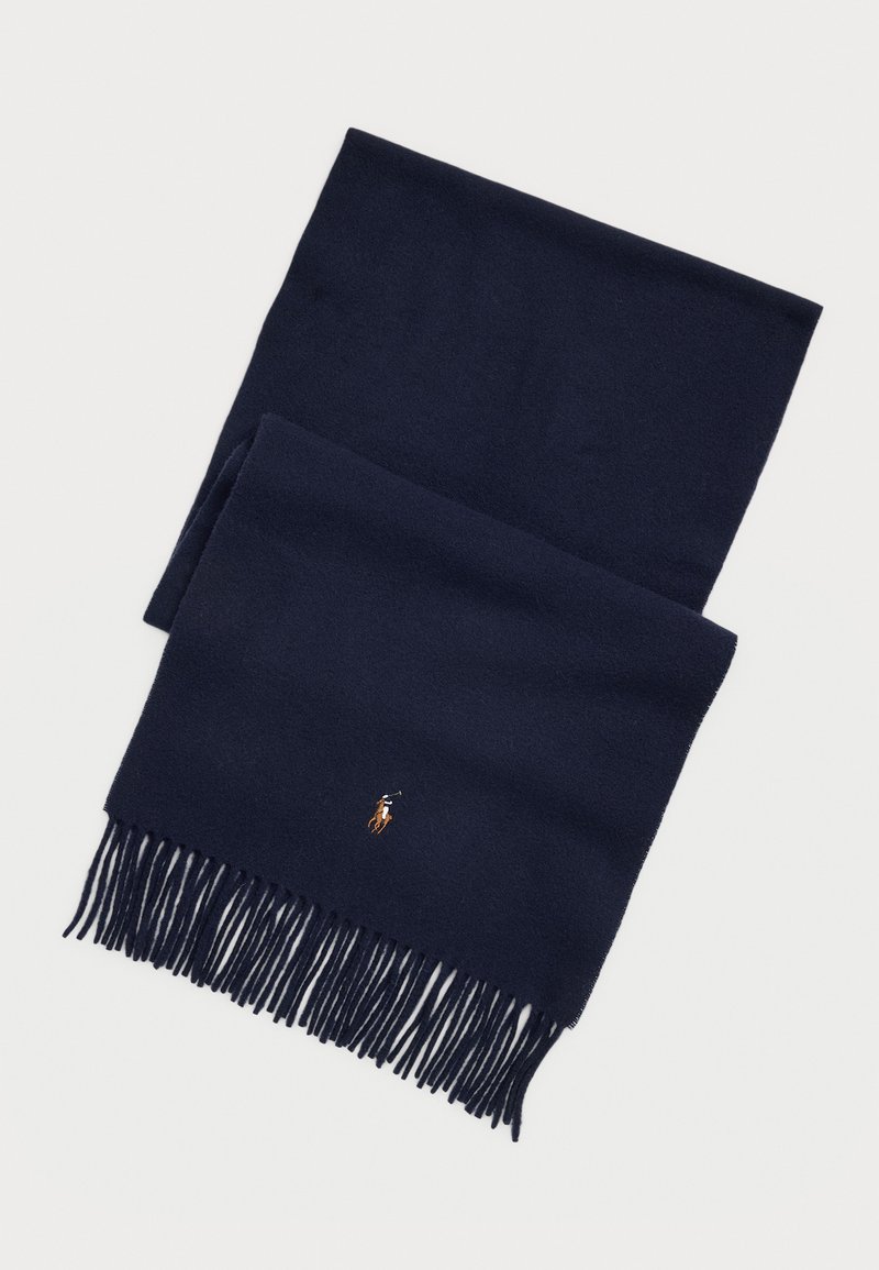 Mørkeblå uldscarf med frynsede kanter og et lille, broderet logo af en rytterskikkelse. Blød tekstur, rektangulær form.